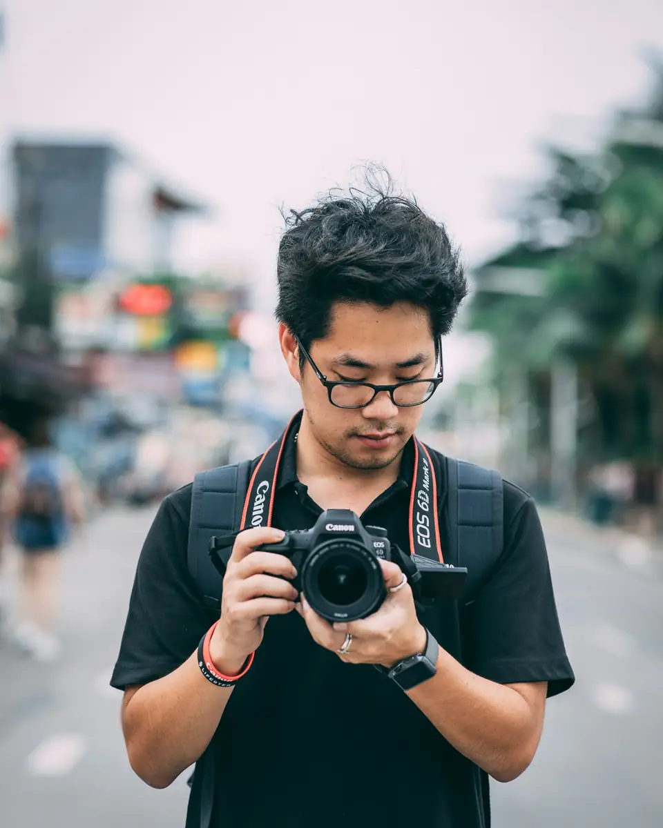 Fotografer memeriksa hasil jepretannya di jalan