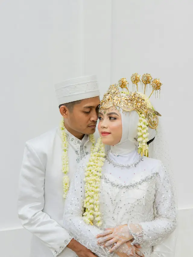 Sepasang pengantin berbusana akad putih