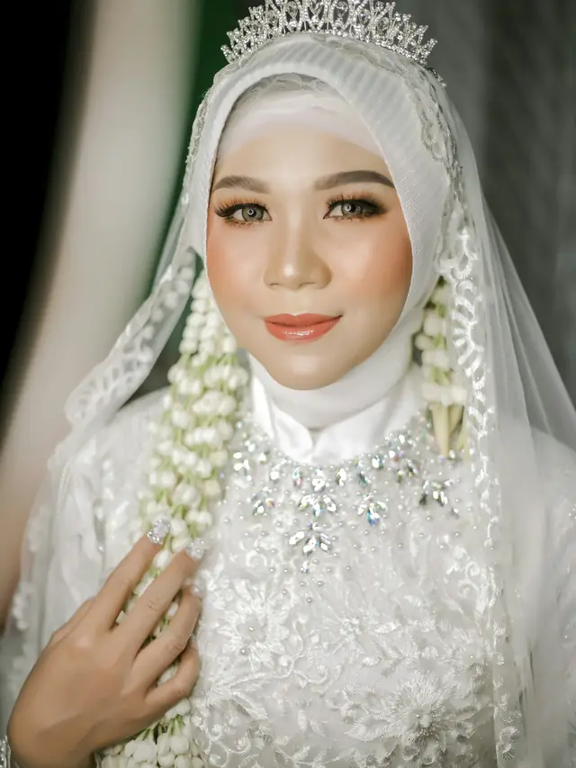 Pengantin berkerudung putih dengan tiara dan ronce melati