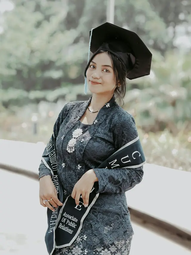Wisudawati berkebaya dengan toga dan selempang