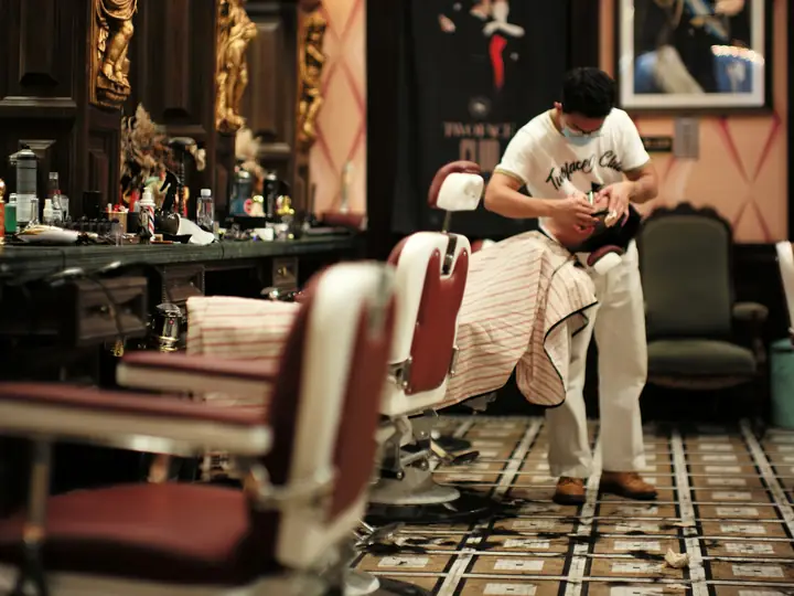 Barber bekerja di barbershop berlantai tegel motif